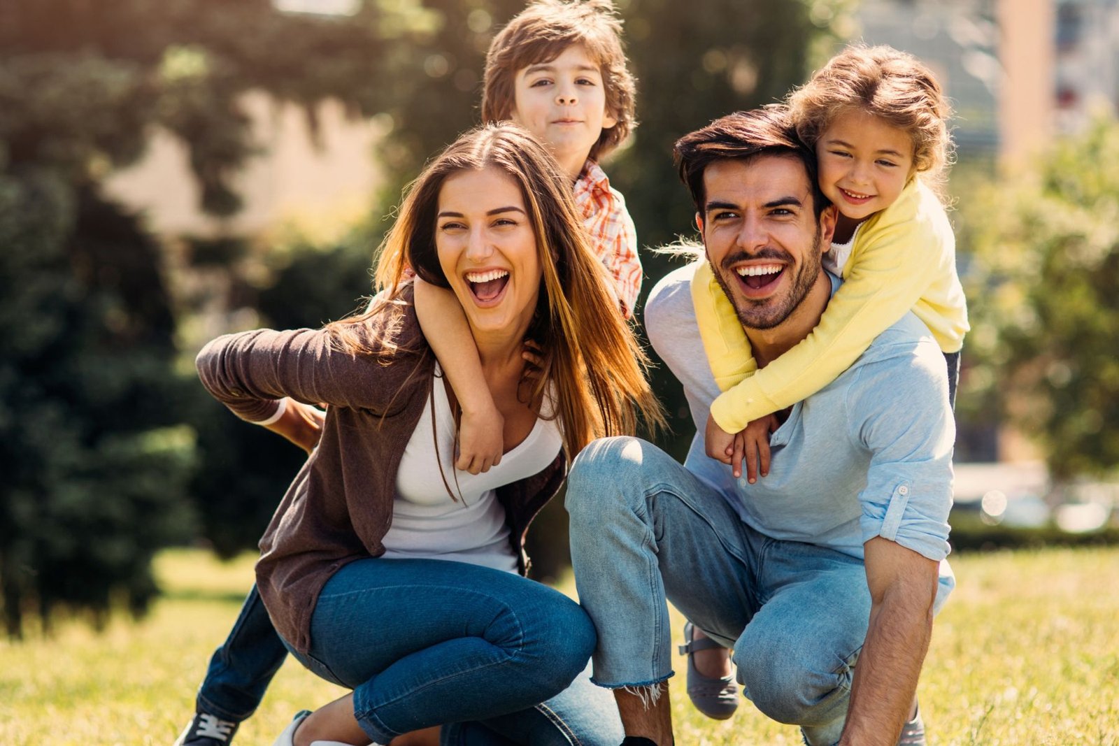 A joyful family of four playing together outdoors